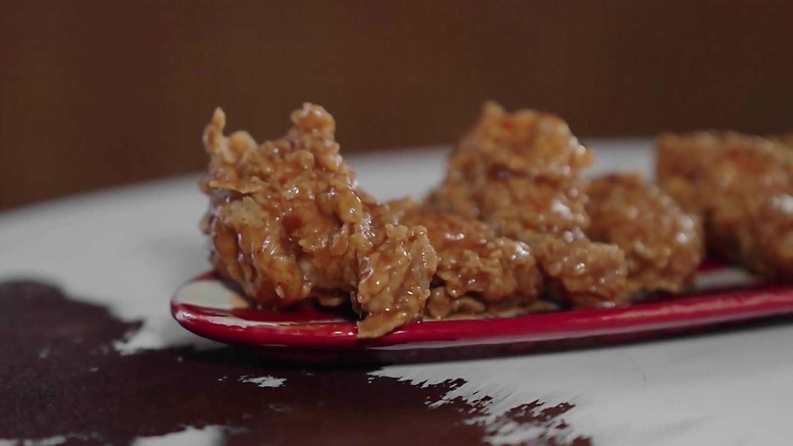 Chicken wings coated in bourbon sauce on a red tray at Harold's